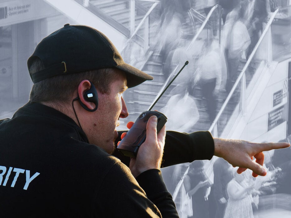 Security guard communicating via radio, monitoring crowd activity, emphasizing professional security services.
