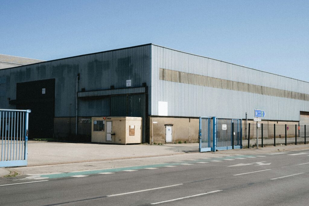 Manufacturing facility exterior with security gate, emphasizing on-site security importance for asset protection and safety.